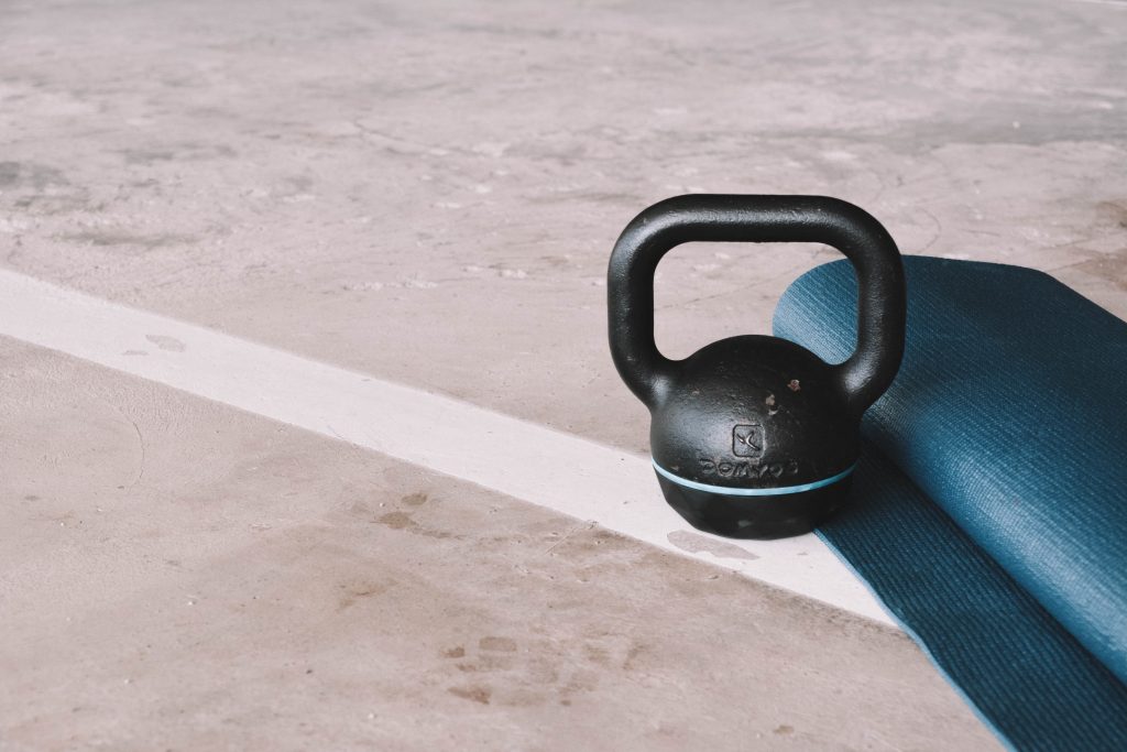 Zwarte kettlebell met opgerolde gymnastiekmat